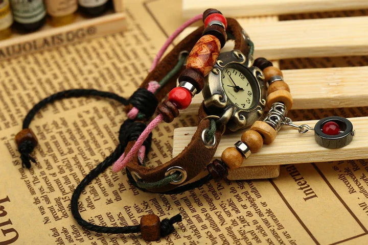 Vintage wristwatch with decorative beads, leather and fabric straps on wooden slats and newspaper background