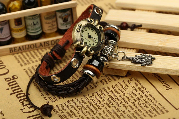 Vintage leather wristwatch bracelet with beads and leaf charm on newspaper background