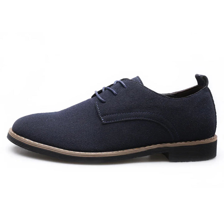 Navy blue suede men's derby shoes with tan stitching and black rubber soles