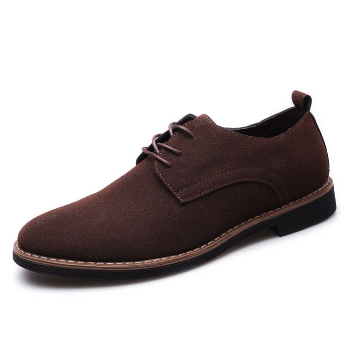 Brown suede men's dress shoe with lace-up design and stitched sole on white background