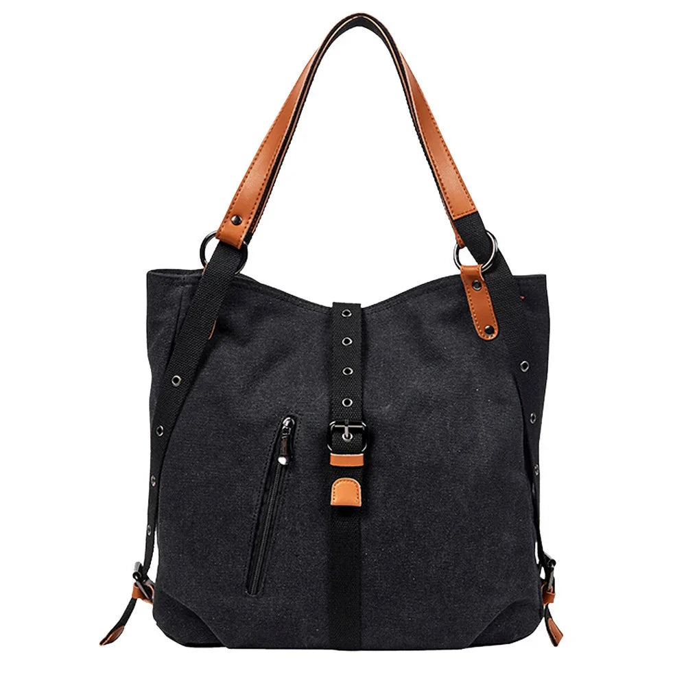Black canvas tote bag with brown leather handles and front buckle detail