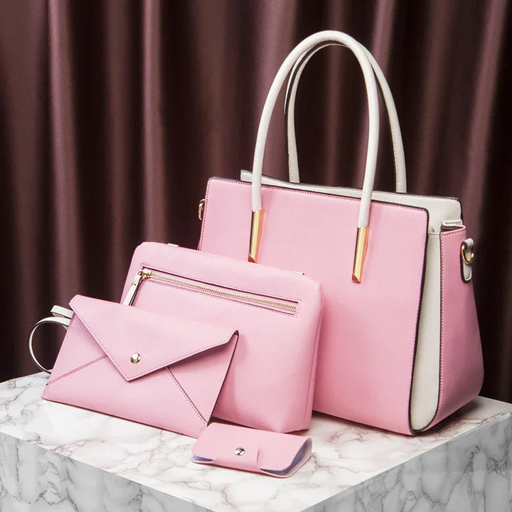 Set of elegant pink faux leather handbags and accessories on marble surface with brown curtain background