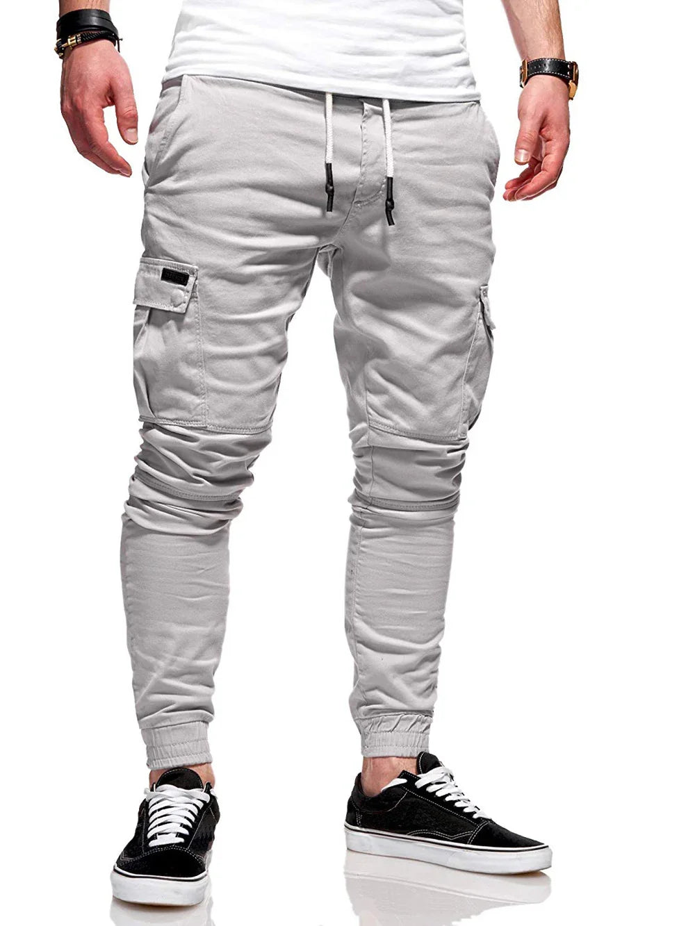 Mens light gray cargo jogger pants with drawstring waist and elastic cuffs paired with black sneakers