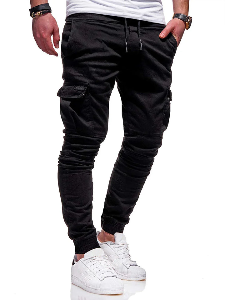 Man wearing black cargo jogger pants with drawstring waist and white sneakers