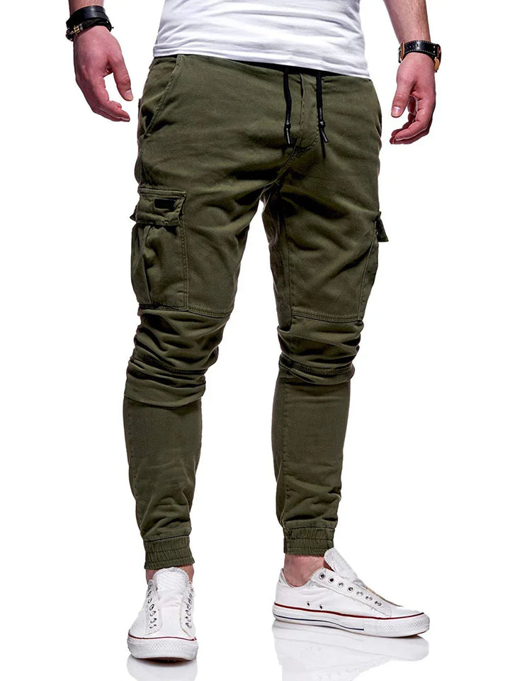 Men's olive green cargo jogger pants with drawstring waist and white sneakers