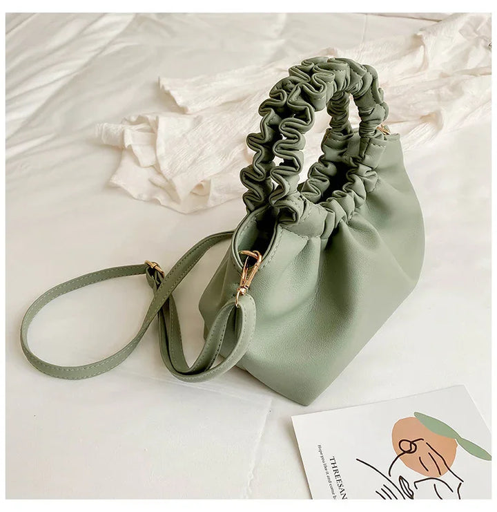 Stylish sage green ruched handle handbag with detachable strap on white fabric background