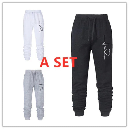 Set of three jogger sweatpants in black, white, and gray with heartbeat and heart graphic