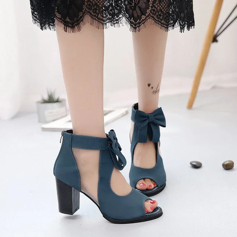 Stylish blue high-heeled sandals with ankle bows and open toes worn with black lace dress