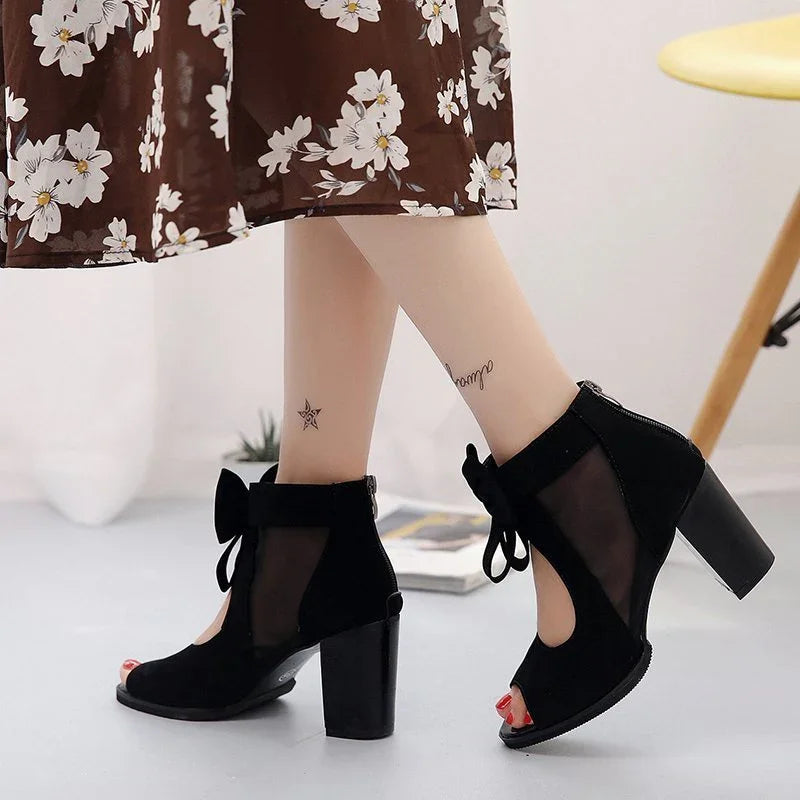Black mesh and suede high heel ankle boots with front bow detail, worn with floral dress