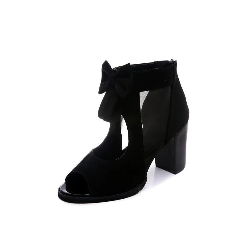Black suede open-toe block heel sandal with ankle strap and decorative bow