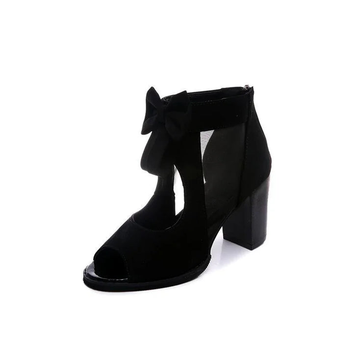 Black suede open-toe block heel sandal with ankle strap and decorative bow
