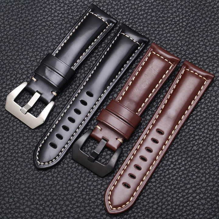 Black and brown leather watch straps with contrasting white stitching on textured black background