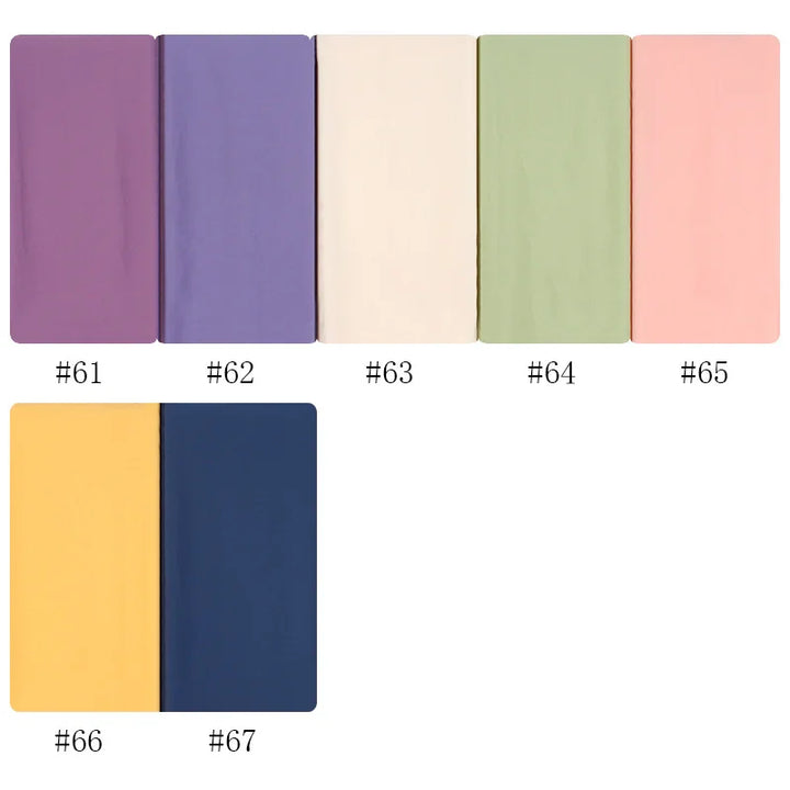 Set of seven solid color fabric swatches in purple, lavender, cream, green, pink, yellow, and navy blue