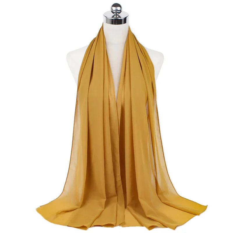 Mustard yellow chiffon scarf displayed on a white mannequin with metallic neck cap
