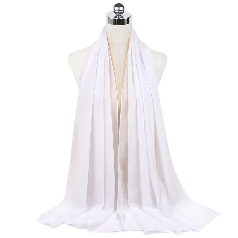 Long white lightweight scarf draped on dress form with chrome top against white background