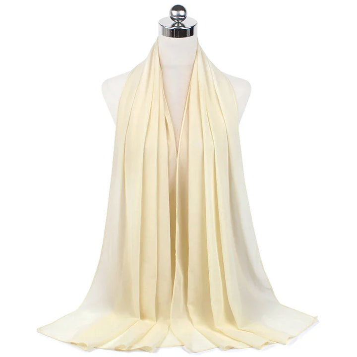 Cream-colored lightweight scarf displayed on mannequin with soft flowing fabric