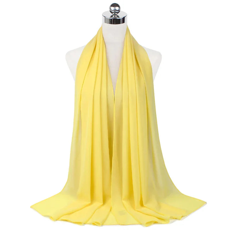 Soft yellow chiffon scarf draped on white mannequin in studio lighting