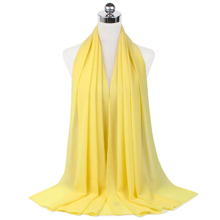 Soft yellow chiffon scarf draped on white mannequin in studio lighting