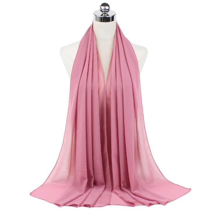 Soft pink chiffon scarf elegantly draped on white mannequin with metallic stand