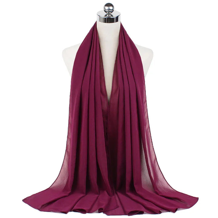 Deep magenta chiffon scarf draped on white mannequin bust with chrome top