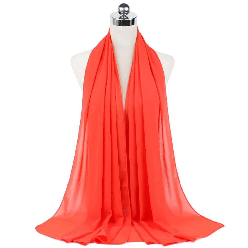 Bright coral orange chiffon scarf displayed on white mannequin bust