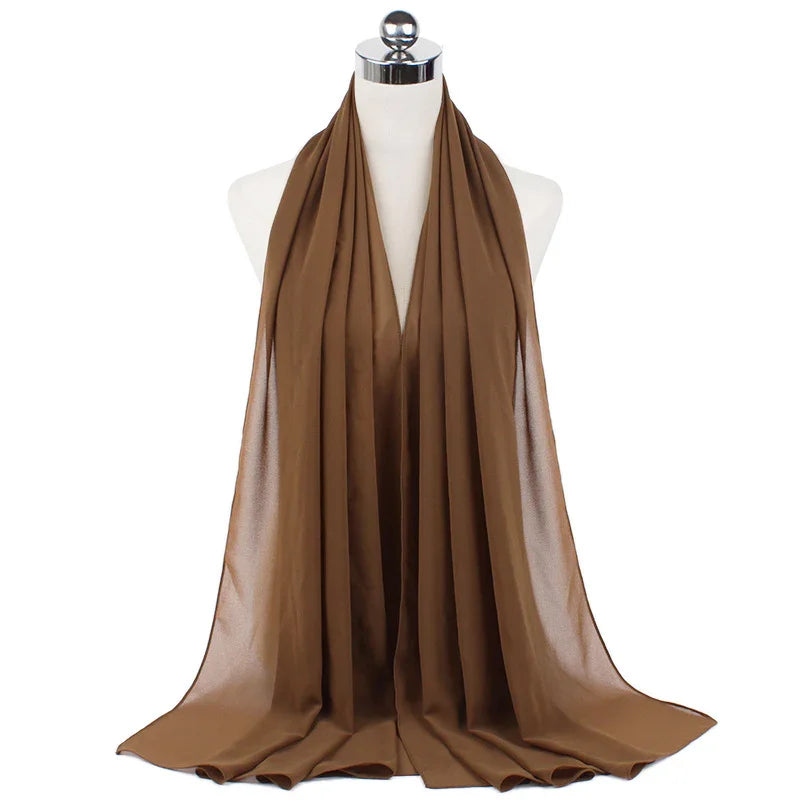 Brown satin scarf draped on white mannequin, smooth shiny fabric with elegant folds