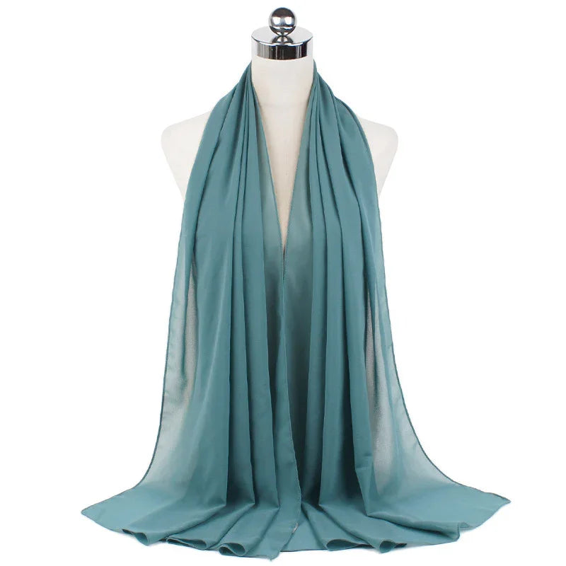 Soft teal chiffon scarf draped on white mannequin bust with shiny silver top
