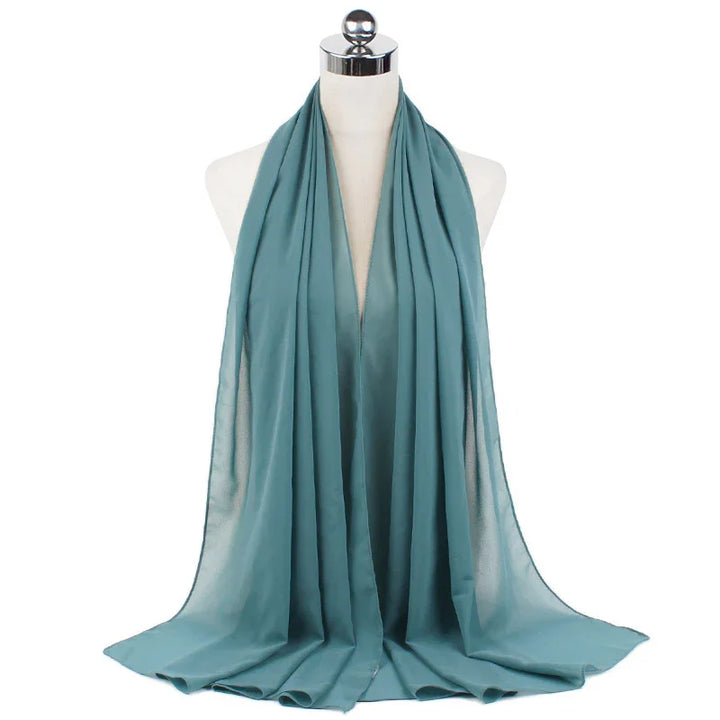 Soft teal chiffon scarf draped on white mannequin bust with shiny silver top