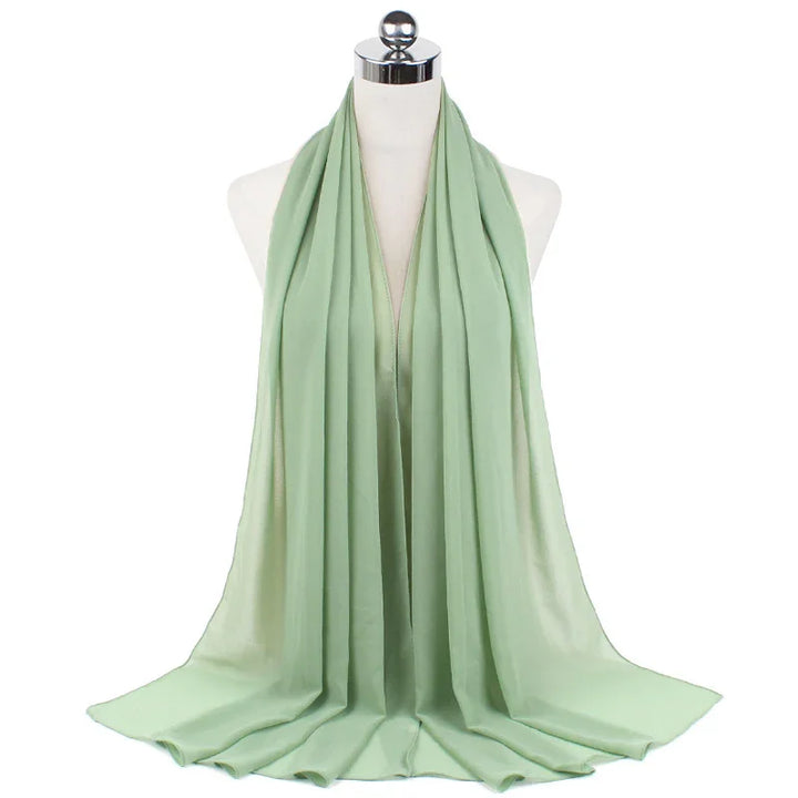 Light green satin scarf draped on white mannequin with reflective silver head