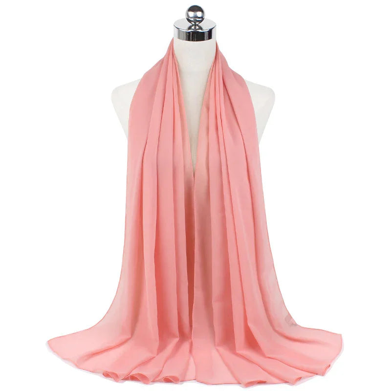 Soft pink chiffon scarf draped elegantly on white mannequin with silver top