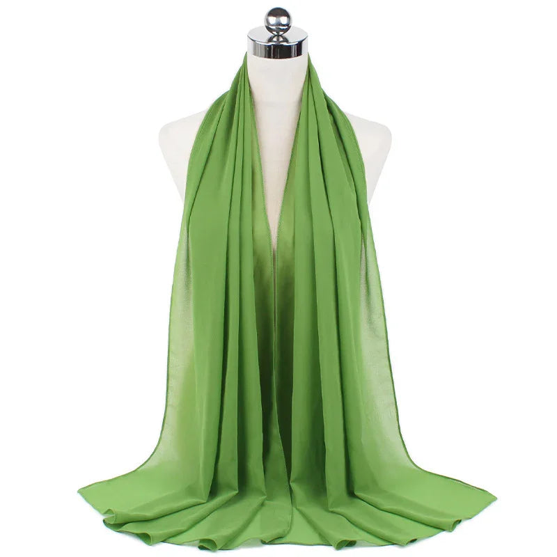 Light green chiffon scarf draped elegantly on dress form mannequin with white background