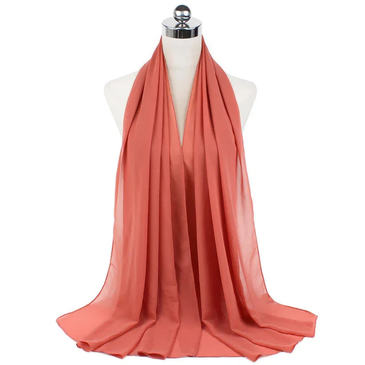 Soft coral pink chiffon scarf draped on white mannequin with silver top