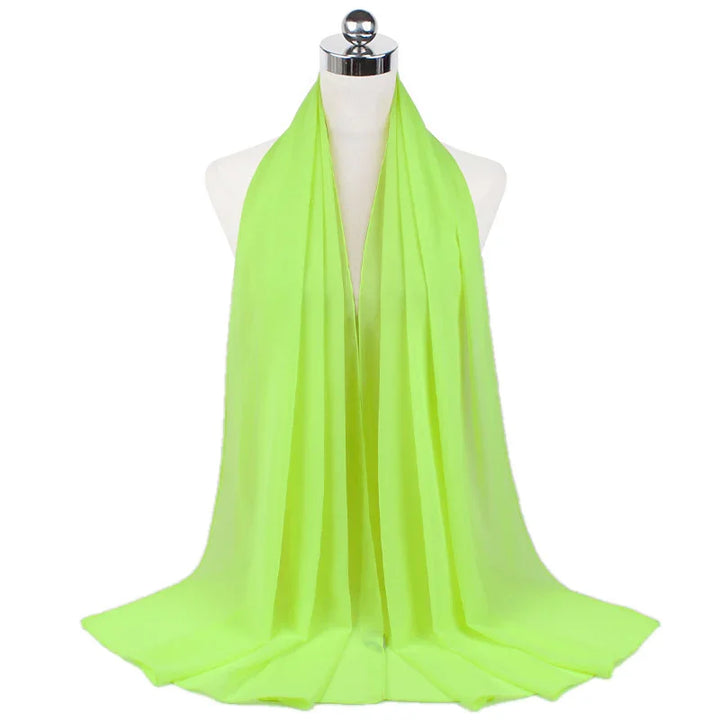 Light green chiffon scarf displayed on white mannequin with silver top on white background