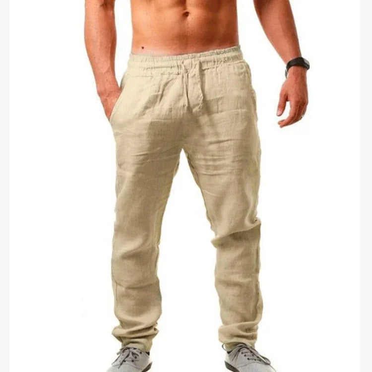 Men's beige linen jogger pants with elastic waist and pockets, styled with casual sneakers