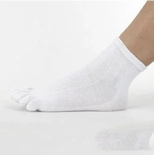 Close-up of a foot wearing a white toe sock on a reflective white surface