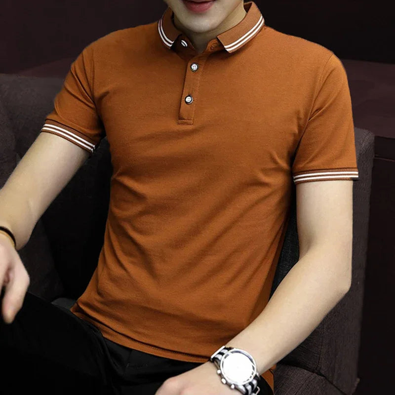 Man wearing rust brown polo shirt with white striped collar and cuffs, black pants, and silver watch
