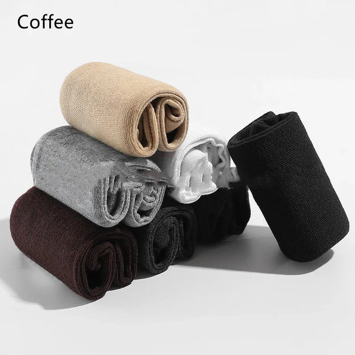 Stack of rolled cotton socks in coffee, gray, white, black, and brown on white background