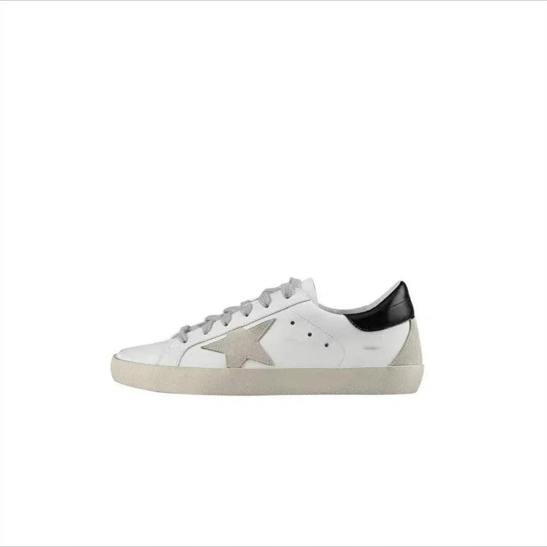 White low-top sneaker with grey star detail and black heel tab on white background