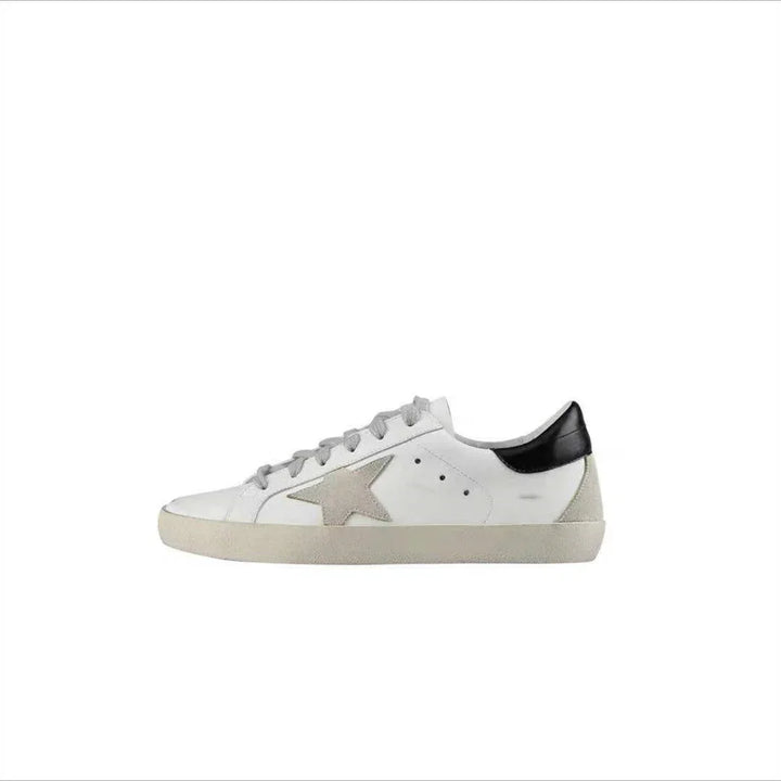 White low-top sneaker with grey star detail and black heel tab on white background