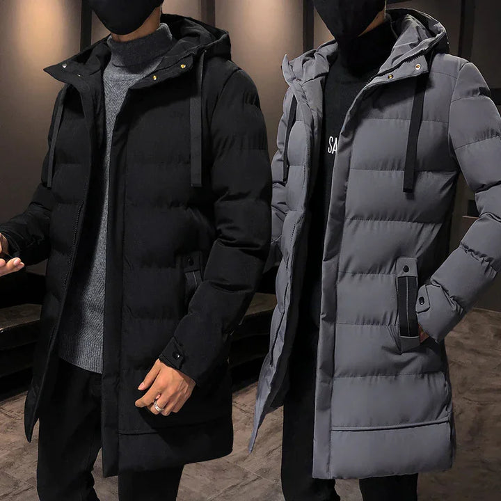 Two men wearing black and gray hooded winter puffer coats with quilted design indoors