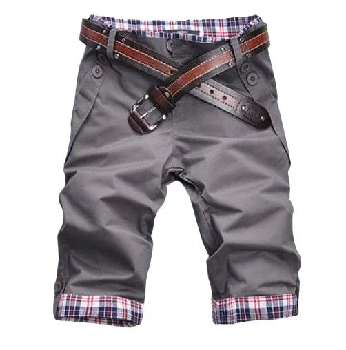 Gray men's casual shorts with plaid lining and brown leather belt on white background