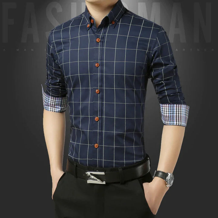 Man wearing navy blue checked dress shirt with rolled sleeves and brown buttons, paired with black trousers and belt