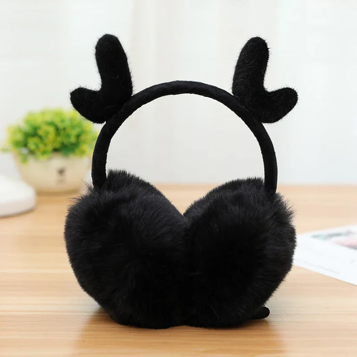 Black fuzzy earmuffs with cute antler design on a wooden table indoor