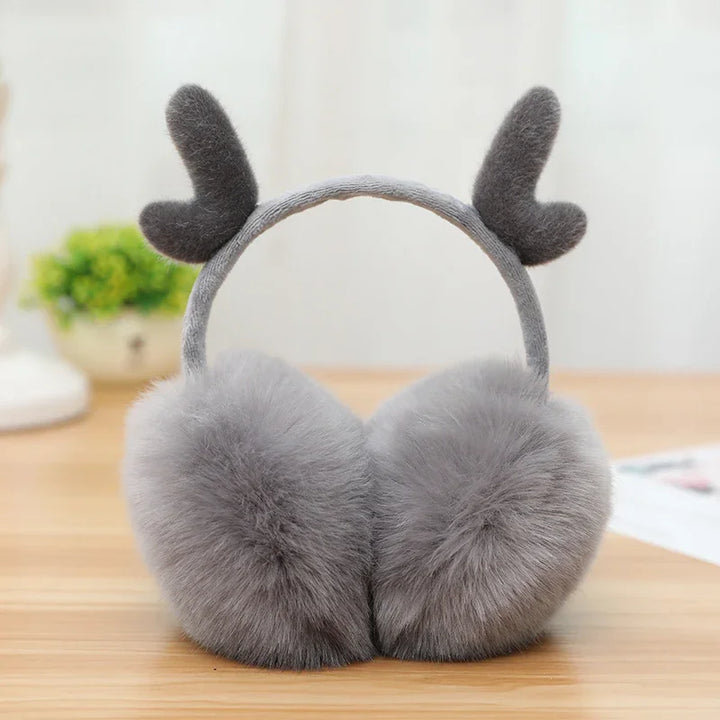 Gray plush earmuffs with soft faux fur and cute reindeer antlers on wooden surface