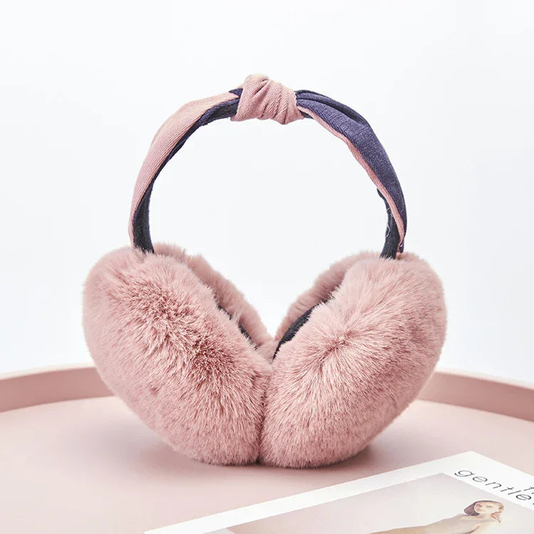 soft pink faux fur earmuffs with knotted fabric headband on pink surface