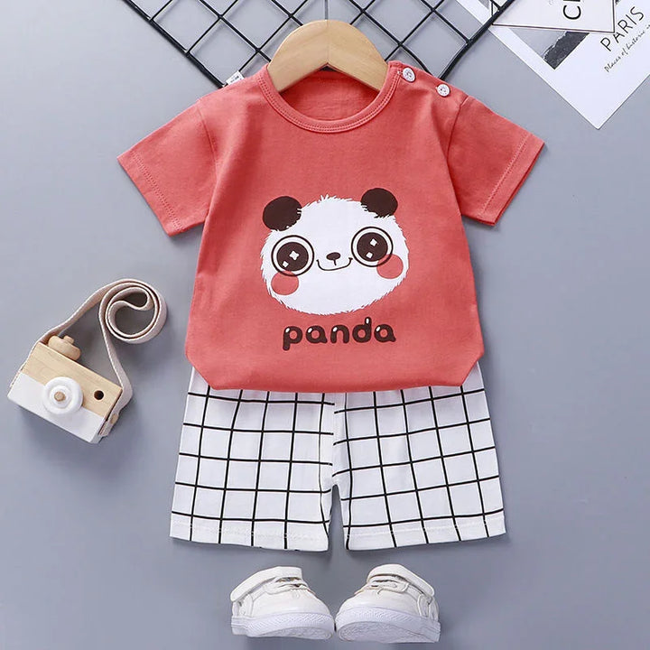 Toddler outfit with red panda print t-shirt, white grid shorts, toy camera, and white sneakers