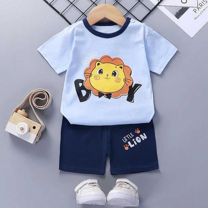 Baby boy outfit with light blue t-shirt featuring a cartoon lion and navy shorts with white sneakers