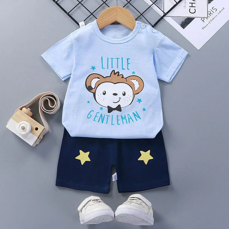 Baby boy outfit with light blue "Little Gentleman" t-shirt featuring bear print, navy shorts with yellow stars, white sneakers