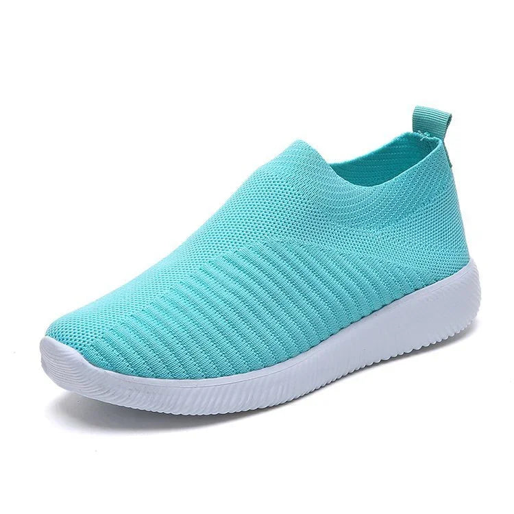 Light blue slip-on knit sneaker with white rubber sole and pull tab at heel