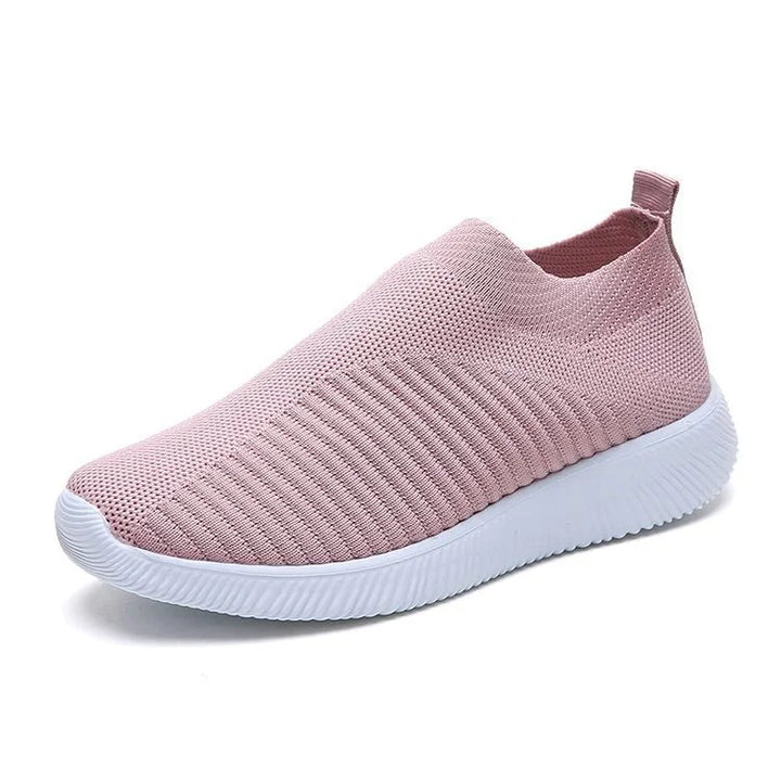 Light pink slip-on knit sneaker with white textured sole and pull tab heel